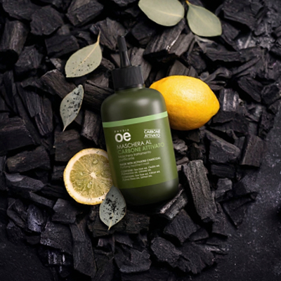 immagine del prodotto della maschera al carbone ambientata su sfondo nero con carbone e limoni 